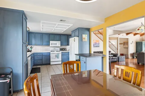 a kitchen with stainless steel appliances kitchen island granite countertop a refrigerator a stove top oven a sink and dishwasher