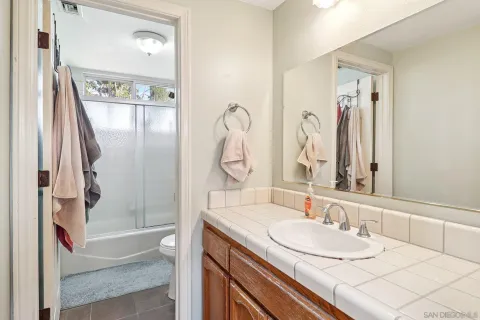 a bathroom with a granite countertop sink a mirror and a shower