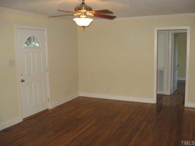 801 Colleton Road Raleigh, NC 27610 - Photo 2 of 12 an empty room with wooden floor and windows
