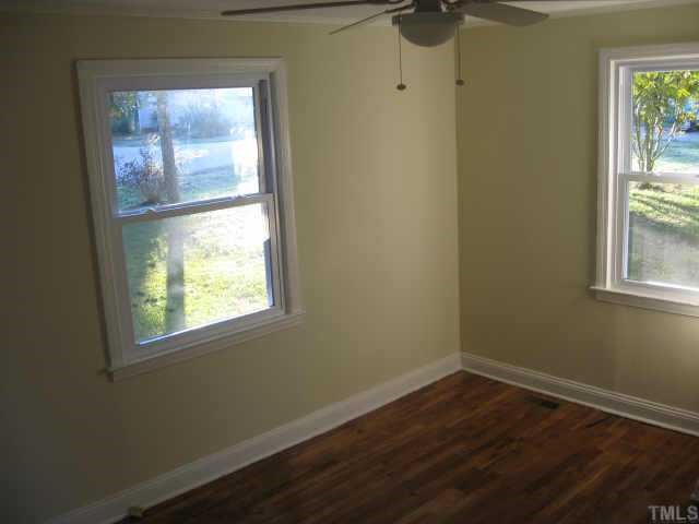 801 Colleton Road Raleigh, NC 27610 - Photo 4 of 12 an empty room with wooden floor and windows