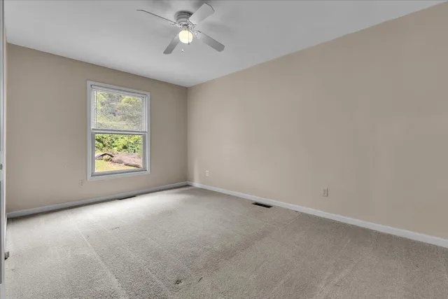 an empty room with closet and fan