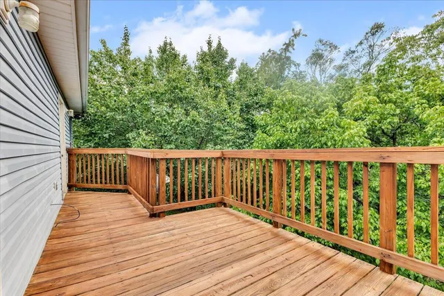 a view of a house with large tree and wooden fence