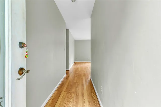 a view of a hallway with wooden floor and staircase