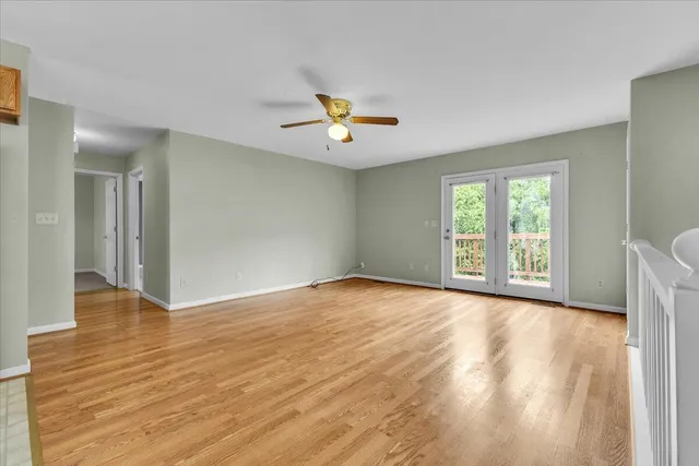 a view of an empty room with window and wooden floor