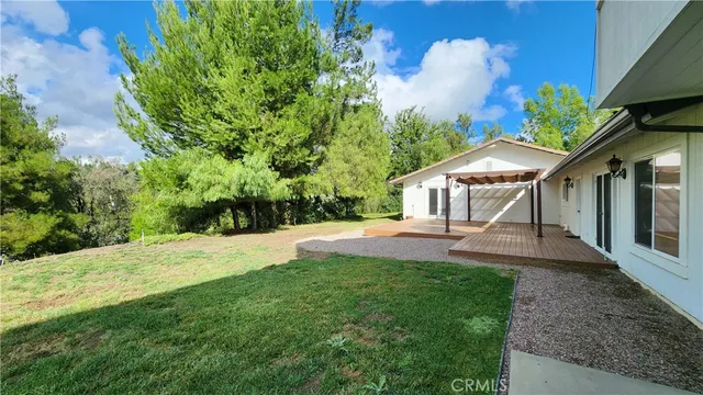 a view of a house with backyard and a sitting area