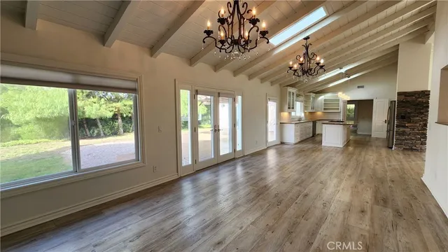 a view of a big room with wooden floor windows and chandelier