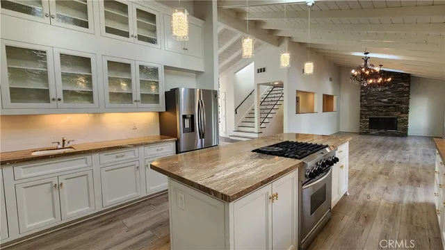 a kitchen with granite countertop a sink stove and refrigerator