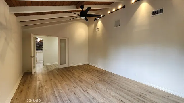 a view of a room with wooden floor a ceiling fan and window
