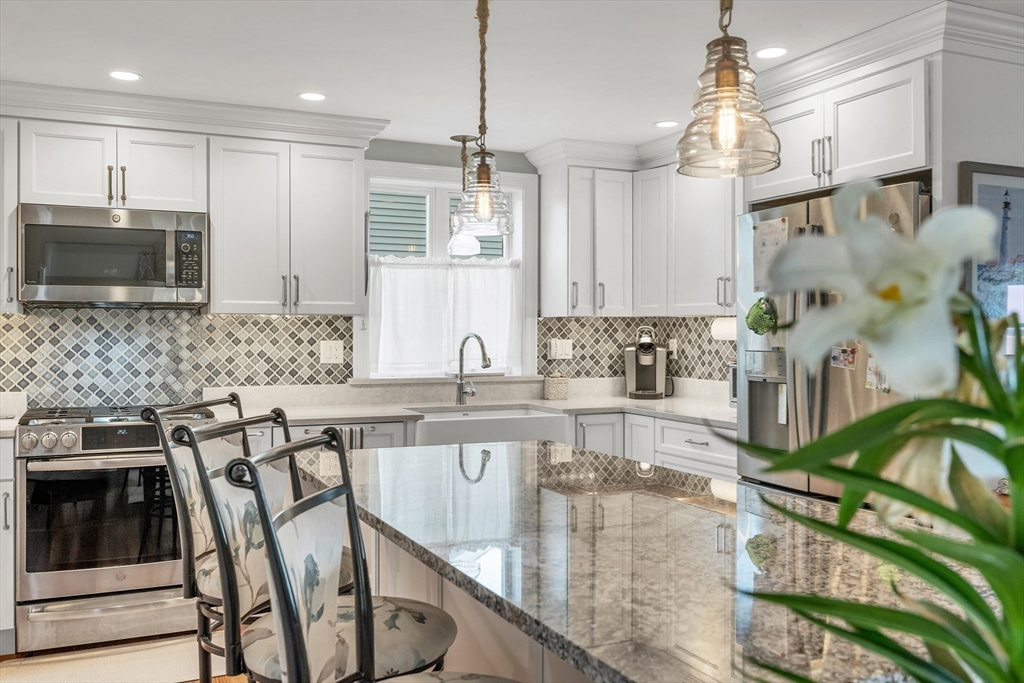 713 Ocean Boulevard Hampton, NH 03842 - Photo 19 of 42 a kitchen with stainless steel appliances granite countertop a sink a stove a microwave a refrigerator and cabinets