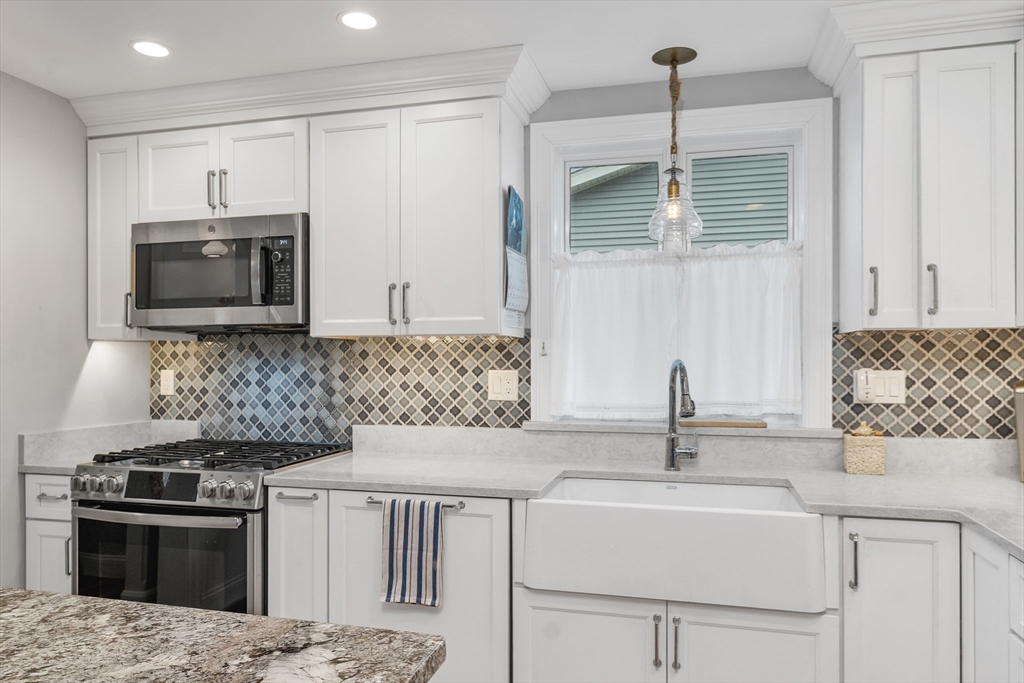 713 Ocean Boulevard Hampton, NH 03842 - Photo 20 of 42 a kitchen with stainless steel appliances kitchen island granite countertop a sink stove and microwave