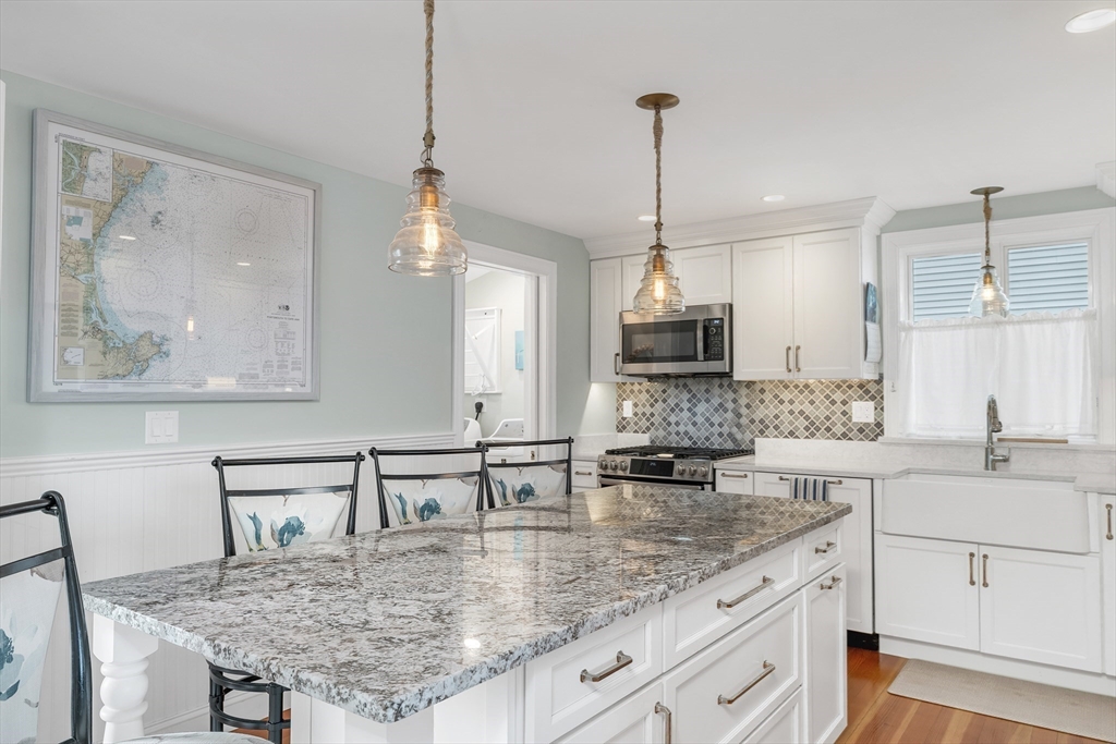 713 Ocean Boulevard Hampton, NH 03842 - Photo 21 of 42 a kitchen with center island table and chairs
