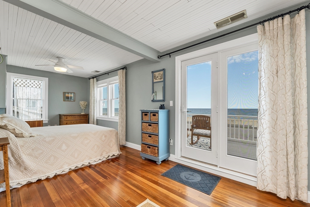 713 Ocean Boulevard Hampton, NH 03842 - Photo 30 of 42 a bedroom with a large bed and a wooden floor