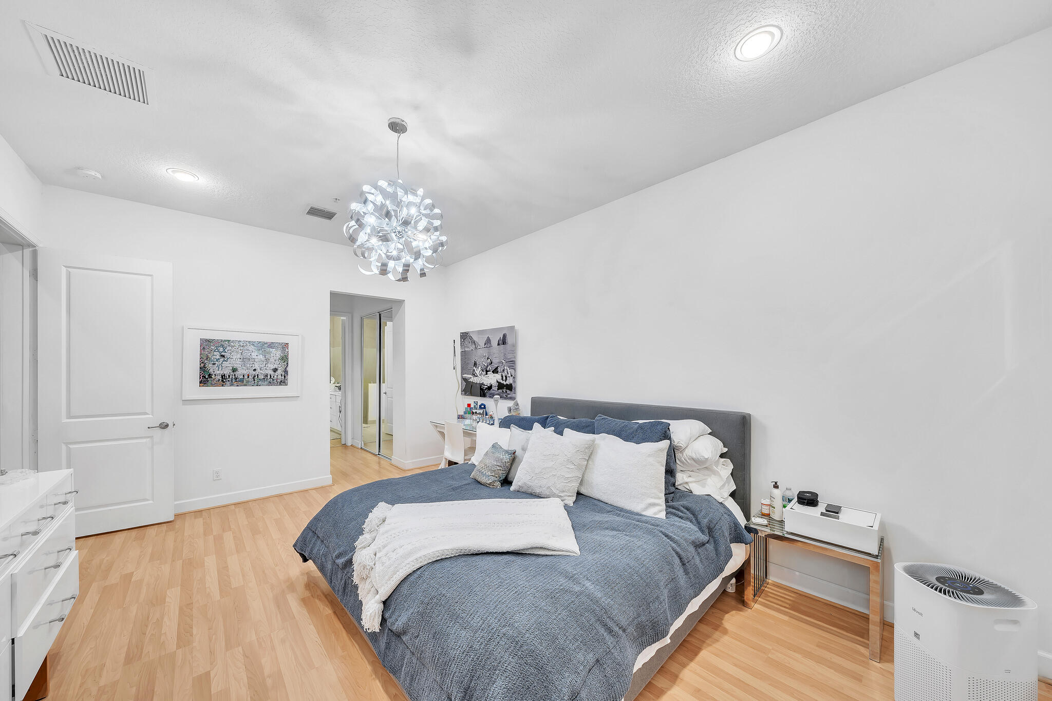 23008 Clear Echo Drive, Unit 11 Boca Raton, FL 33433 - Photo 32 of 64 a spacious bedroom with a bed and a chandelier