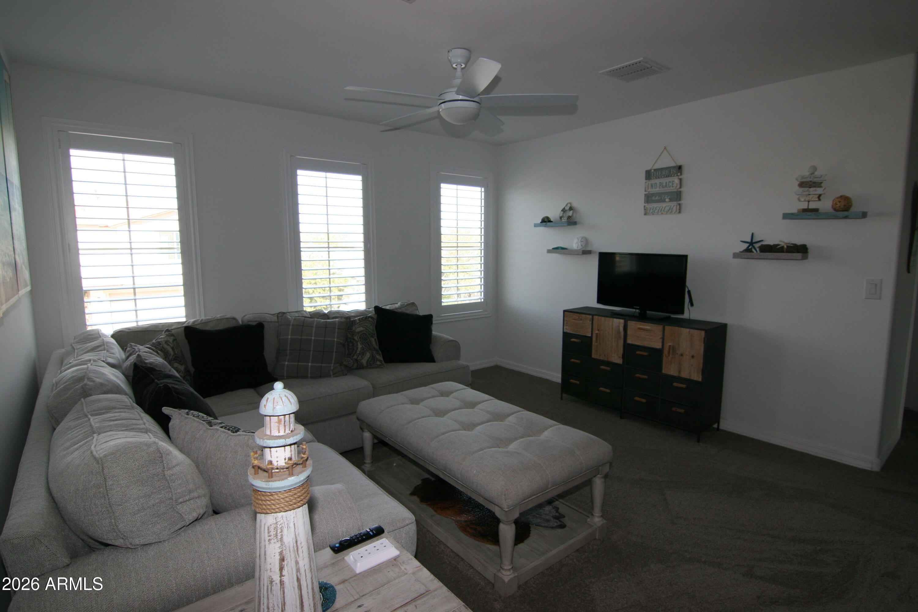 18487 West Ipswitch Way Surprise, AZ 85374 - Photo 12 of 36 a living room with furniture a flat screen tv and a window