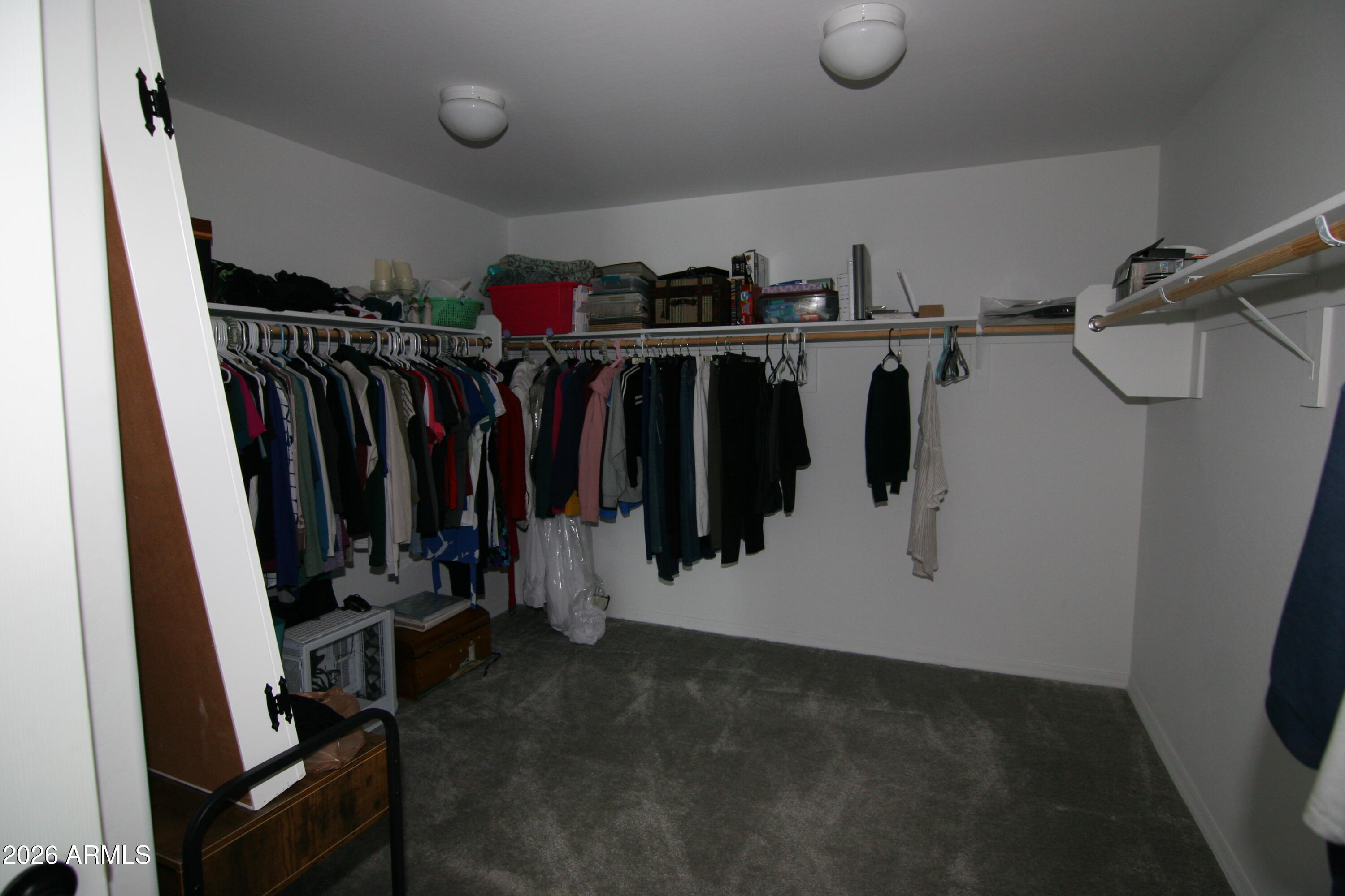 18487 West Ipswitch Way Surprise, AZ 85374 - Photo 7 of 36 a view of walk in closet with clothes and shoes
