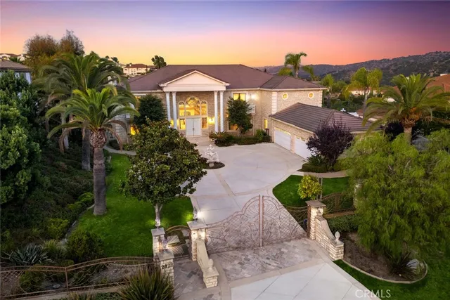 a front view of a house with a yard and mountain view in back