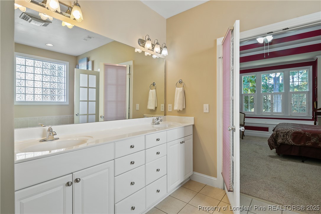 383 Falling Water Road Spring Lake, NC 28390 - Photo 23 of 33 a en suite bathroom with a double vanity sink a mirror a window and a shower
