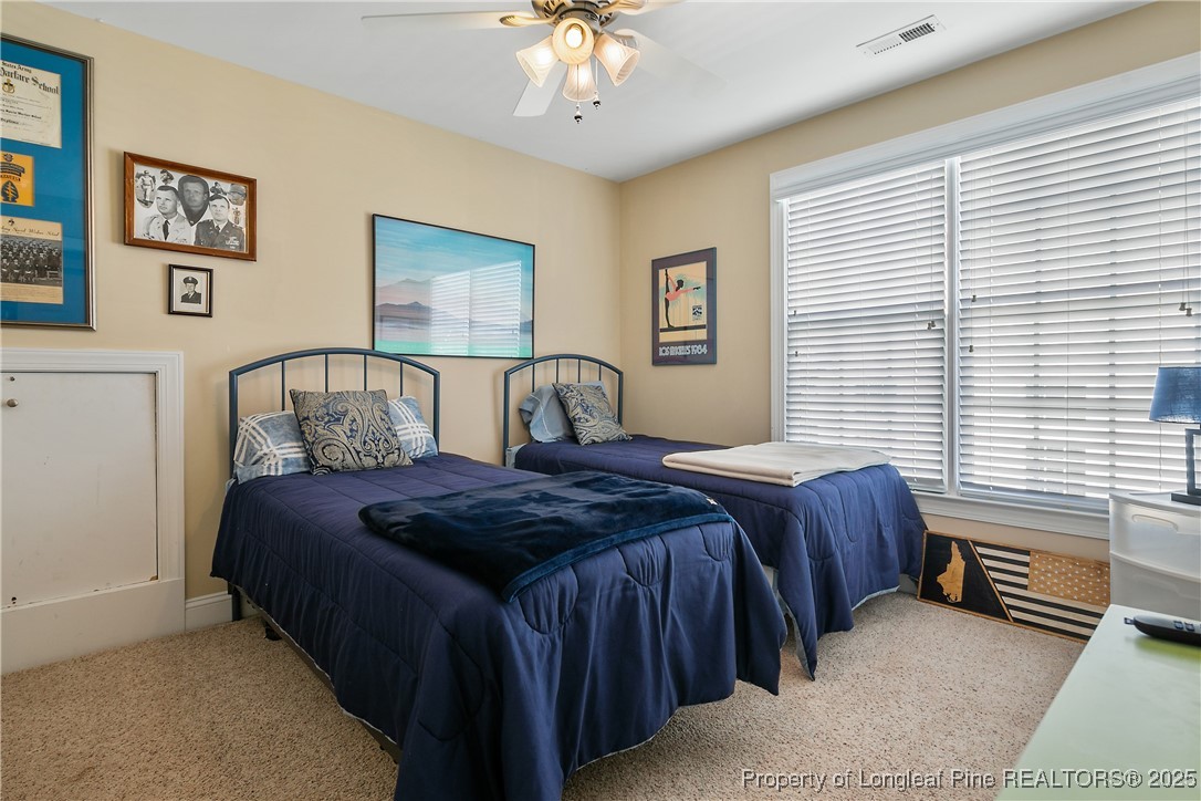383 Falling Water Road Spring Lake, NC 28390 - Photo 30 of 33 a bedroom with a bed and a chandelier