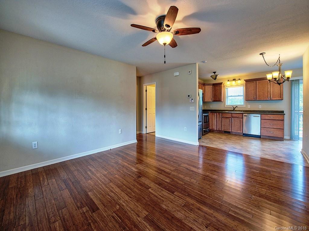 54 Barefoot Ridge Clyde, NC 28721 - Photo 5 of 24 a view of a kitchen with a dishwasher a kitchen island with wooden floor and chandelier