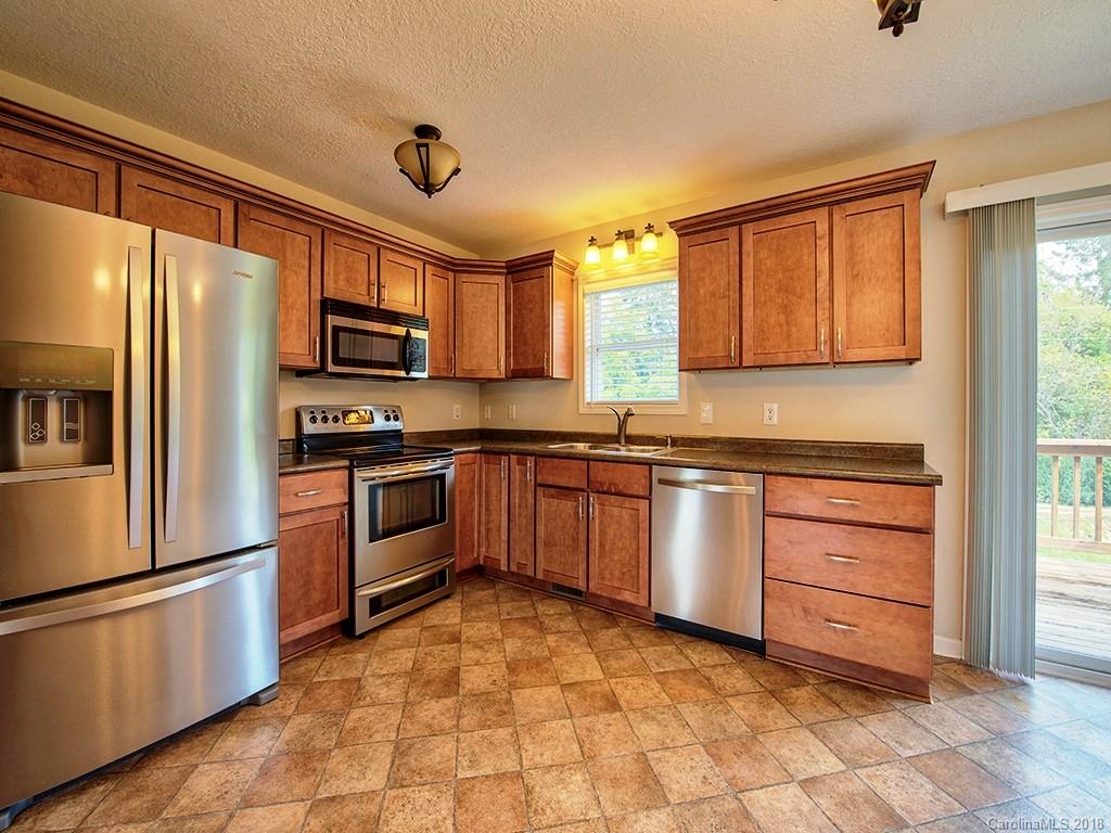 54 Barefoot Ridge Clyde, NC 28721 - Photo 8 of 24 a kitchen with granite countertop a refrigerator and a stove top oven