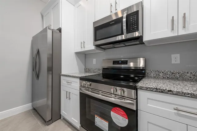 a kitchen with stainless steel appliances granite countertop a stove microwave and refrigerator