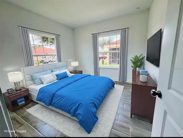 a bedroom with a large bed and a flat screen tv