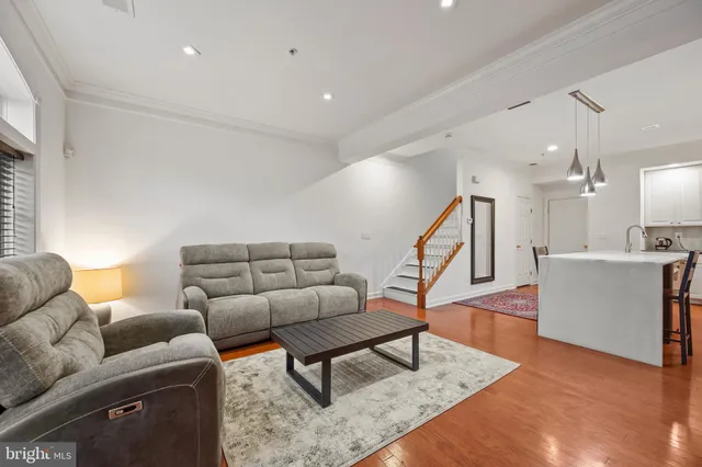 a living room with furniture and a wooden floor