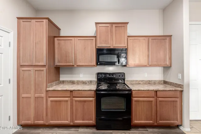 a kitchen with granite countertop wooden cabinets and a stove top oven