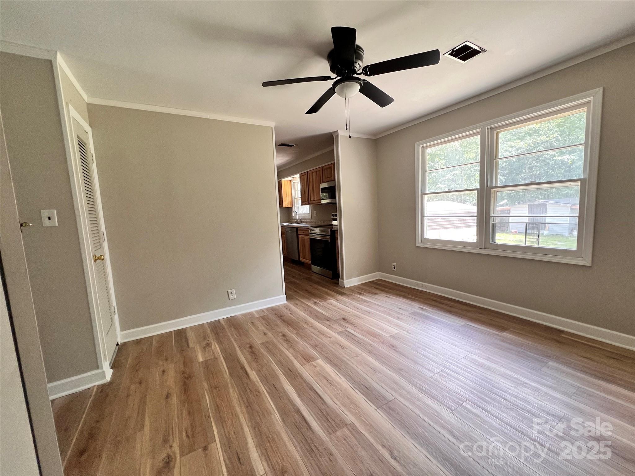 405 West Inwood Street Bethune, SC 29009 - Photo 3 of 22 a view of an empty room with a window and wooden floor