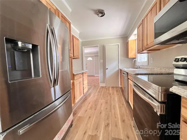 a kitchen with stainless steel appliances a refrigerator and a stove
