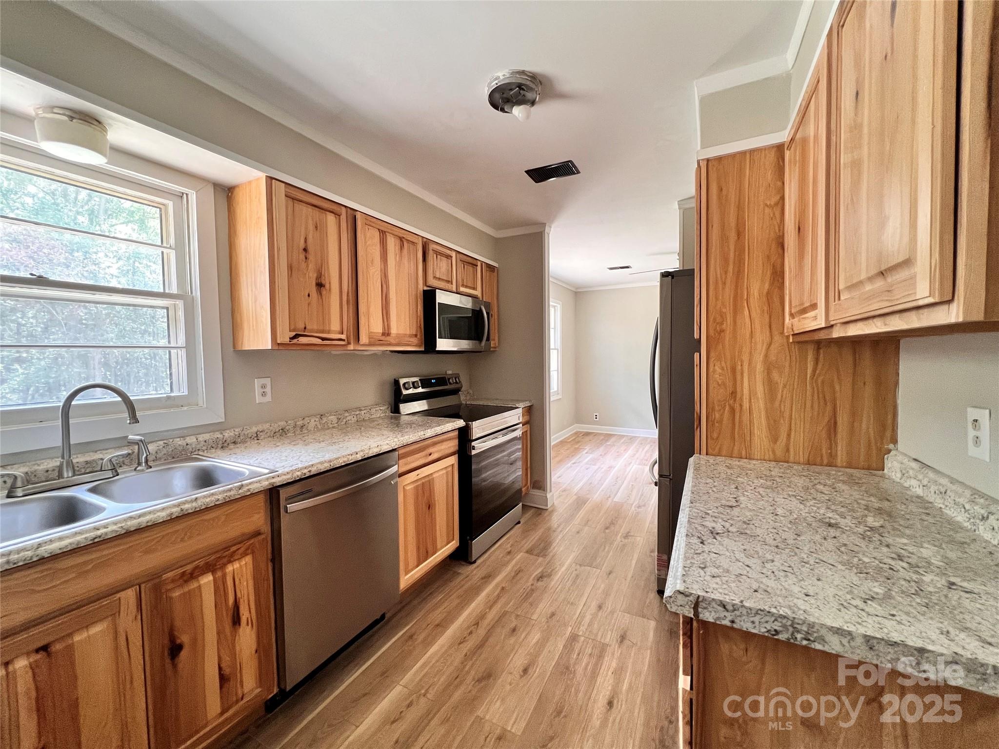 405 West Inwood Street Bethune, SC 29009 - Photo 6 of 22 a kitchen with stainless steel appliances granite countertop wooden cabinets a sink and dishwasher with wooden floor