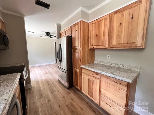 a kitchen with granite countertop wooden floors and stainless steel appliances