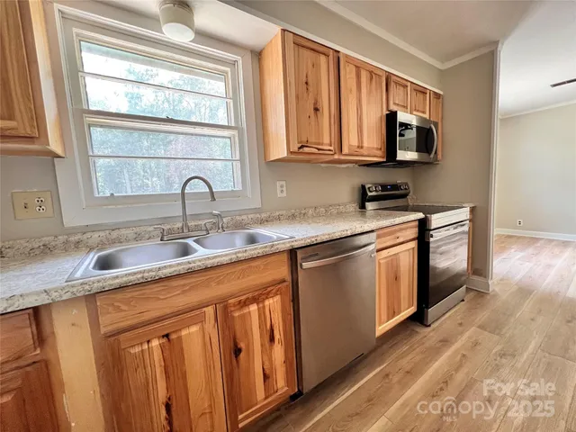 a kitchen with stainless steel appliances granite countertop a sink stove and microwave