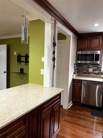 a kitchen with stainless steel appliances granite countertop wooden cabinets a refrigerator and a sink