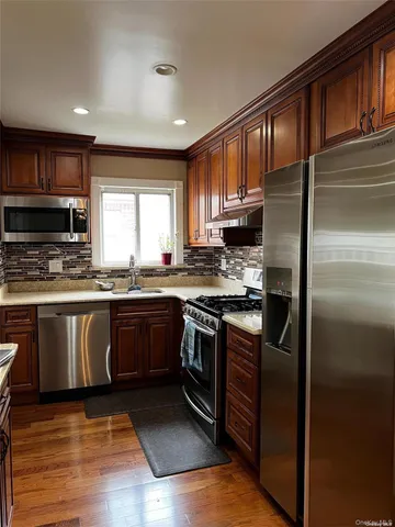a kitchen with granite countertop a refrigerator stove top oven and sink