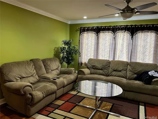 a living room with furniture a couch and a ceiling fan