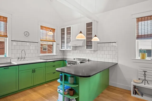 a kitchen with a sink and a stove next to a window