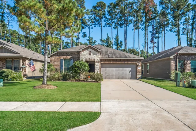 a front view of a house with a garden and trees