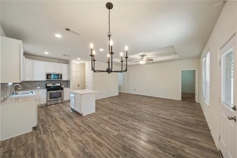 a kitchen with a sink a counter top space stainless steel appliances and cabinets
