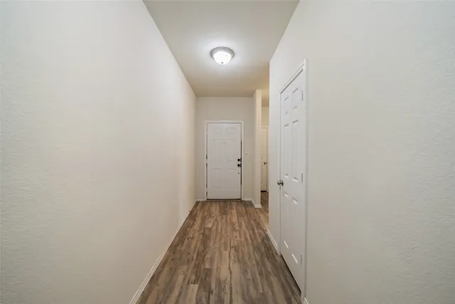 a view of a hallway with wooden floor