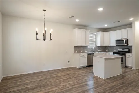 a kitchen with a refrigerator and white cabinets