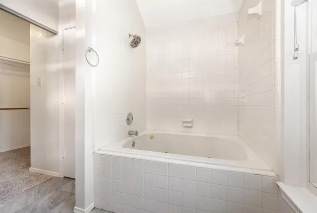 a white bath tub sitting next to a bathroom sink
