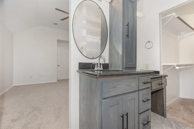 a bathroom with a granite countertop double vanity sink and a mirror