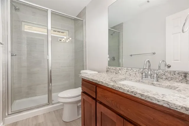 a bathroom with a granite countertop sink toilet and shower
