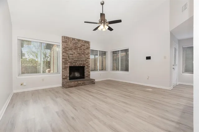 a view of empty room with wooden floor and fireplace