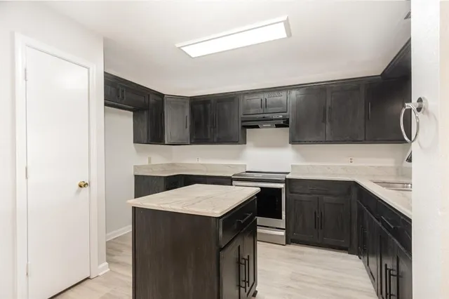 a kitchen with stainless steel appliances a sink stove and refrigerator