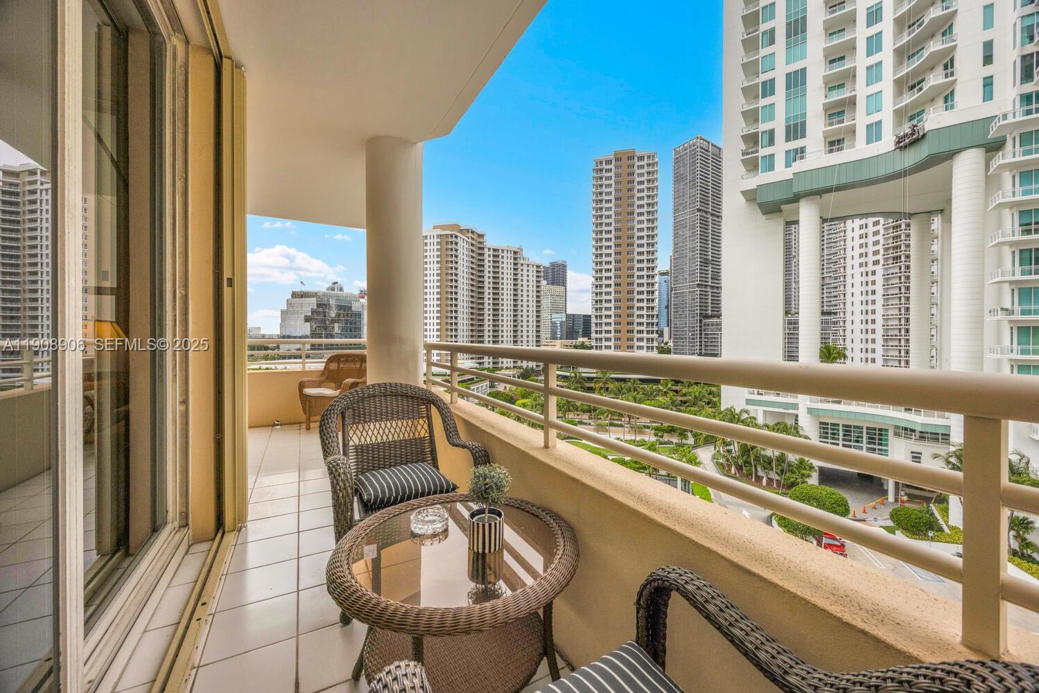 888 Brickell Key Drive, Unit 1001 Miami, FL 33131 - Photo 12 of 15 a balcony with chairs and table
