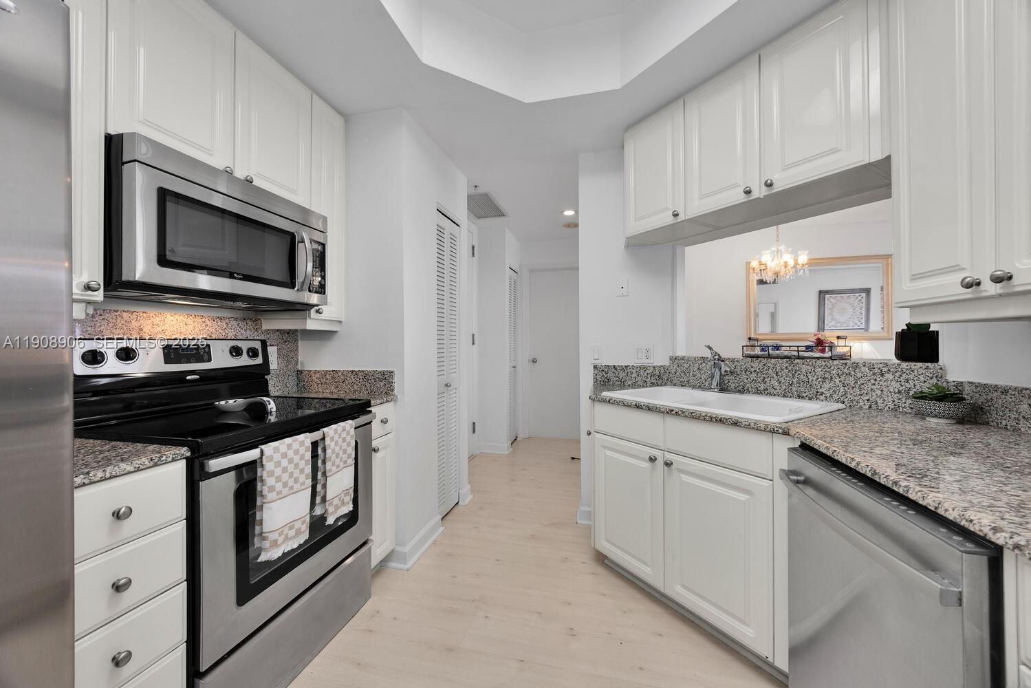 888 Brickell Key Drive, Unit 1001 Miami, FL 33131 - Photo 9 of 15 a kitchen with stainless steel appliances granite countertop a stove a sink and a microwave
