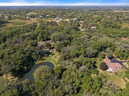 an aerial view of residential houses with outdoor space and trees