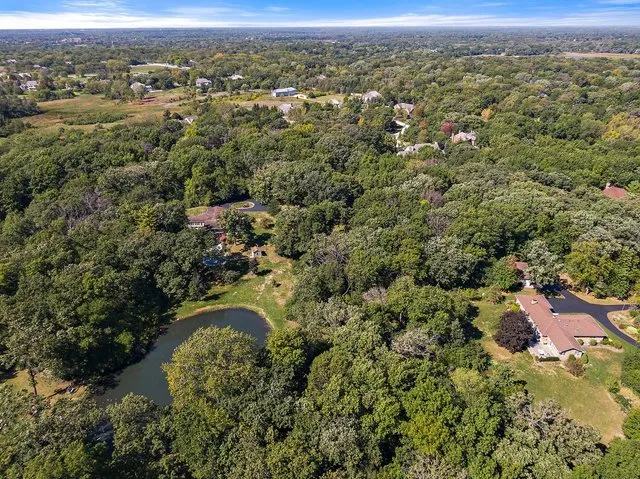 an aerial view of residential houses with outdoor space and trees